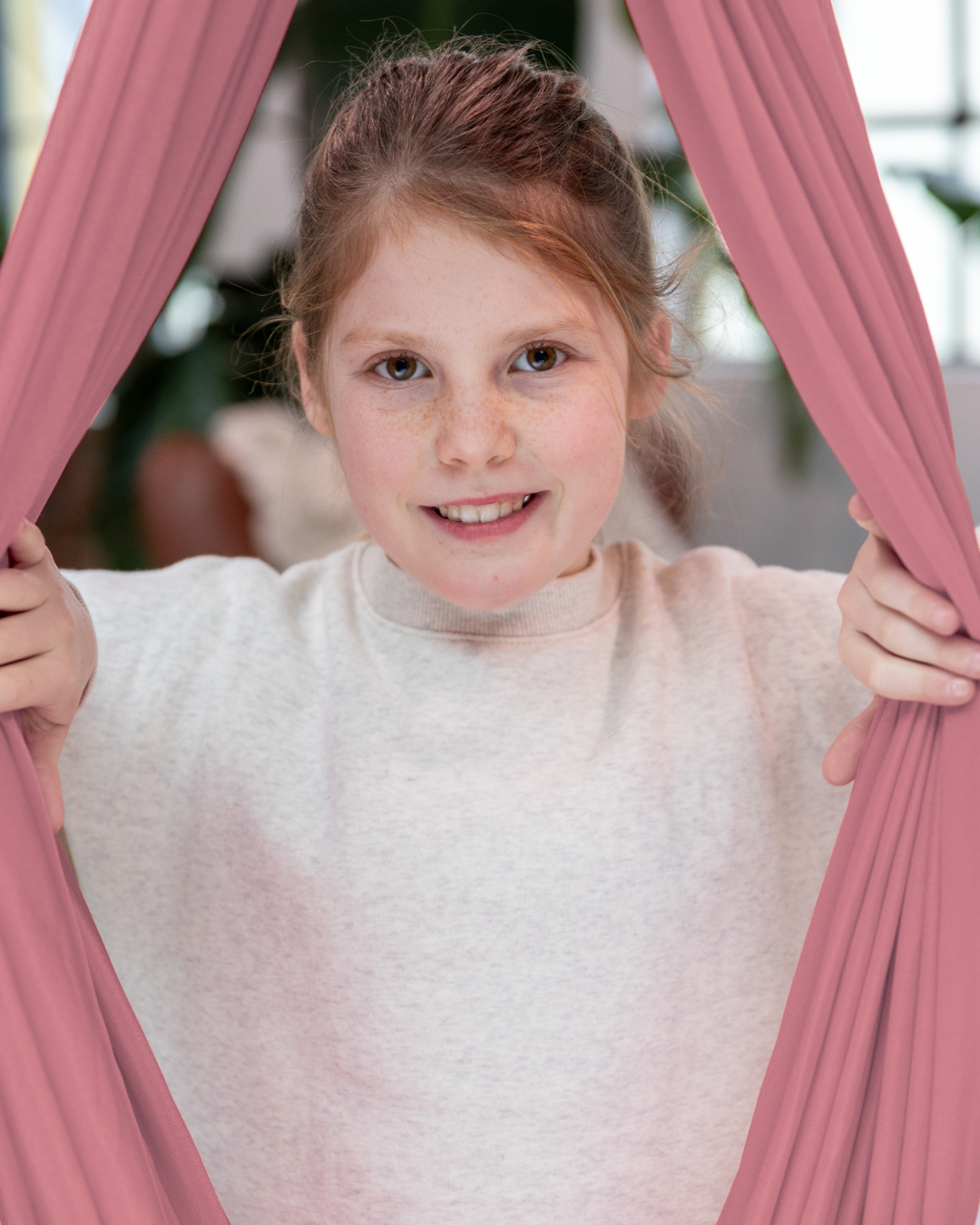 Fröhliches Mädchen in rosa Therapieschaukel aus Nylon – Jolovi Schaukeltuch für Kinder